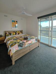 a bedroom with a bed with a view of the ocean at Sitara Cottage in Yanakie