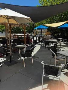 an outdoor patio with tables and chairs and umbrellas at Mount Pleasant Hotel in Mount Pleasant