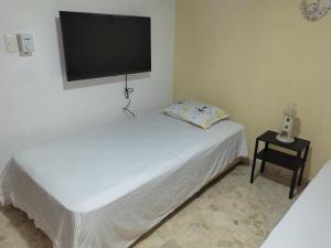 a bedroom with two beds and a flat screen tv at Double bed room in Santo Domingo