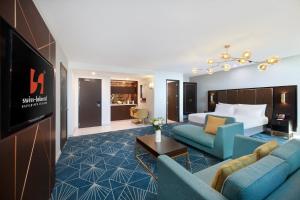a hotel room with a king bed and a living room at Swiss-Belhotel Napier in Napier +35 photos