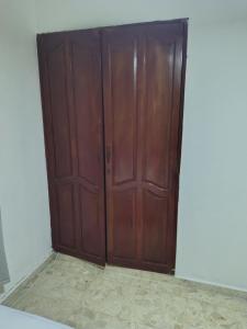 a pair of wooden doors in a room at Double bed room in Santo Domingo