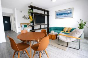 a living room with a table and chairs and a couch at Downtown Skyline Heights with Stunning Ocean View in Miami