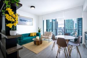 a living room with a green couch and a table at Downtown Skyline Heights with Stunning Ocean View in Miami
