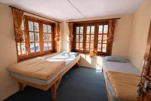 a bedroom with two beds and two windows at Phakding Camp One Lodge in Phakding