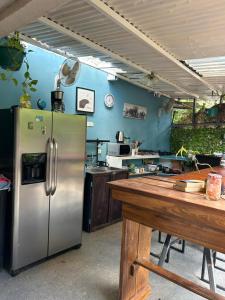 a kitchen with a stainless steel refrigerator and a wooden table at The Backside House - Women Only - in Tamarindo