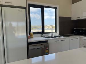 a kitchen with a sink and a window at Moore Memories Beach House in Guilderton