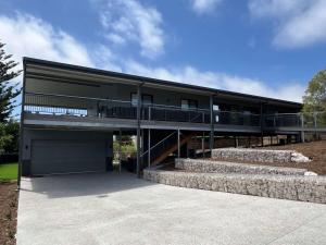 a large building with a garage and stairs at Moore Memories Beach House in Guilderton