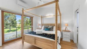 a bedroom with a canopy bed and a large window at Bendigo Lakeside in Eaglehawk