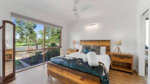 a bedroom with a large bed and a large window at Bendigo Lakeside in Eaglehawk