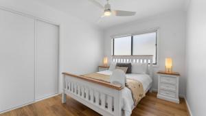 a white bedroom with a bed and a window at Bendigo Lakeside in Eaglehawk