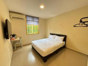a bedroom with a bed and a window and a television at Skudai Sojourn in Skudai