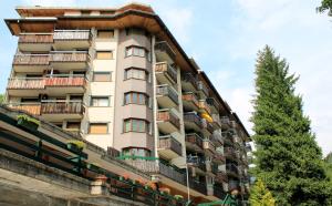 a tall apartment building with balconies and a tree at Casa Rivalta by Holiday World in Limone Piemonte