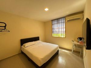a bedroom with a bed and a television in it at Skudai Sojourn in Skudai