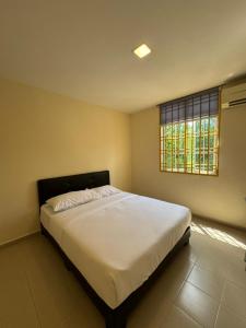 a bedroom with a large white bed with a window at Skudai Sojourn in Skudai