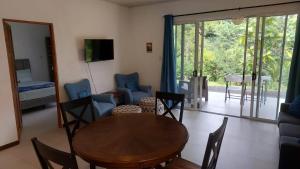 a living room with a wooden table and chairs at Villas Pura Vida - Guapinol in Río Negro