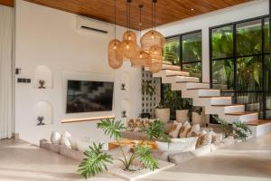 a staircase in a living room with couches and plants at Sapta Cemagi - Villa Deluna in Cemagi