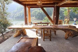 a pavilion with tables and chairs in front of a lake at little Island in Na Lúng