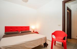 a bedroom with a red bed and a red chair at Casa Herea in Ragusa