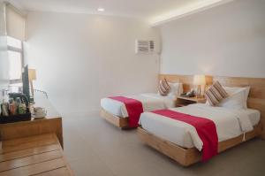 a hotel room with two beds and a television at Bay's Inn Resort in Baler +58 photos