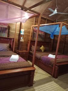 a bedroom with two bunk beds in a cabin at Phum Khnhom Bungalow in Battambang