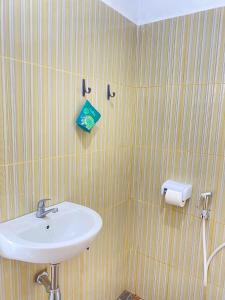 a bathroom with a sink and a towel at De Silaa House & Pool in Bangli