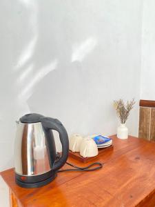a tea kettle on top of a wooden table at De Silaa House & Pool in Bangli