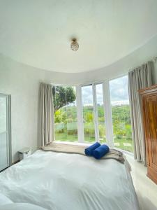 a large bed in a room with a large window at De Silaa House & Pool in Bangli