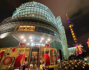 a large building with a tower in the background at Oriental Riverside Bund View Hotel (Shanghai International Convention Center) in Shanghai
