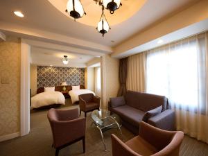 a hotel room with a bed and a couch and chairs at Nikko Station Hotel Classic in Nikko