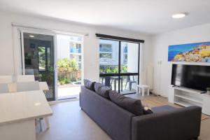 a living room with a couch and a flat screen tv at West Beach Lagoon 206 Ground Floor 2mins beach in Perth