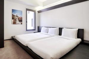 a bedroom with two white beds and a window at Sotetsu Hotels The Splaisir Seoul Myeongdong in Seoul