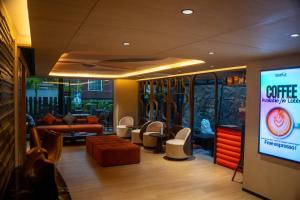 a living room with a couch and a tv at Shine Aparthotels Sukhumvit Thonglor in Bangkok