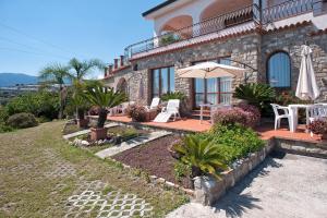 Cette maison dispose d'une terrasse avec une table et un parasol. dans l'établissement Le Terrazze Appartamenti Vacanze, à Sanremo