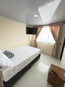 a bedroom with a bed and a window at Hotel Plaza de Toros in Manizales