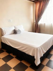 a large bed in a room with a checkered floor at Hotel Plaza de Toros in Manizales