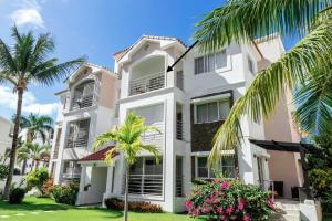 a white building with palm trees in front of it at Corte Sea A302, Luxury Penthouse in Punta Cana