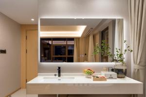 a bathroom with a sink and a mirror at Surprise Hotel Chengdu in Chengdu
