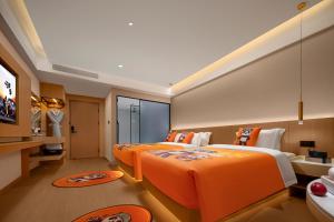 two beds in a hotel room with orange sheets at Surprise Hotel Chengdu in Chengdu