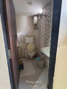 a small bathroom with a toilet and a sink at Hotel New Vinayak in Ahmedabad