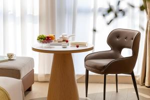 a table with a chair and a bowl of fruit on it at Surprise Hotel Chengdu in Chengdu +22 photos