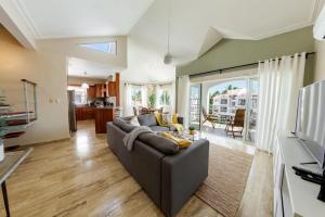 a living room with a couch and a tv at Corte Sea A302, Luxury Penthouse in Punta Cana