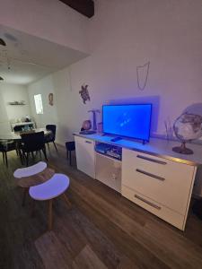 a living room with a flat screen tv on a cabinet at Appartement dans résidence in Muret