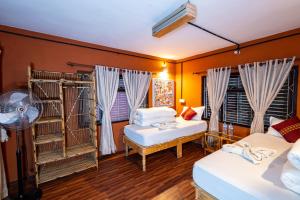 ein Zimmer mit zwei Betten und zwei Fenstern in der Unterkunft Wander Thirst in Kathmandu + 289 Fotos