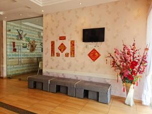 a waiting room with a bench and a tv on the wall at 888 Boutique Hotel in Batu Pahat