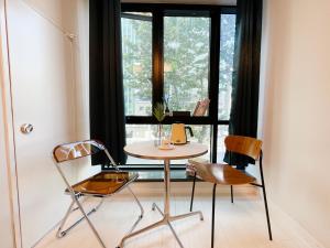 a table and two chairs in front of a window at 엠지스테이 서면 Mzstay Modern Hotel in Seomyeon in Busan