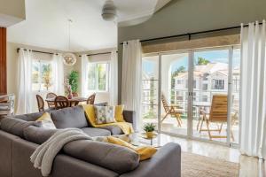 a living room with a gray couch and a large window at Corte Sea A302, Luxury Penthouse in Punta Cana