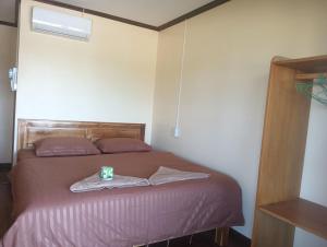 a bedroom with a bed with a cup on it at Thiptavanh guesthouse in Don Det