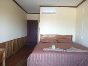 a bedroom with a large bed with a purple blanket at Thiptavanh guesthouse in Don Det
