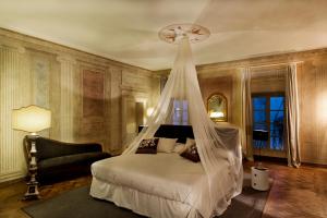 a bedroom with a bed with a mosquito net at Cortona Charme in Cortona