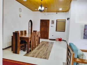 a dining room with a wooden table and chairs at Scenic Lanka rooms in Dehiwala